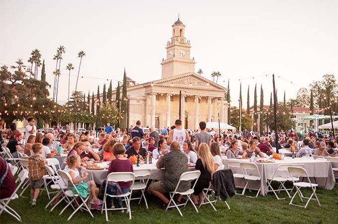 People gather on the Quad lawn during twilight at the University of Redlands during Homecoming weekend.